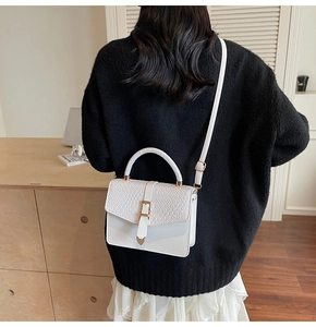 Détail du petit sac blanc avec rabat tissé et fermoir élégant en métal doré chic