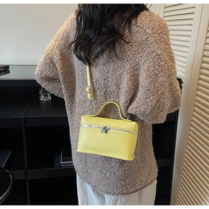 Vue détaillée du sac boîte en cuir jaune avec fermeture éclair et bandoulière