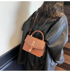Sac à main marron à texture crocodile avec boucle triangulaire dorée et bandoulière