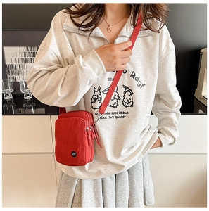 Detailed view of red nylon multi-layer crossbody bag with LYT logo and adjustable strap
