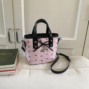 Pink puffy bow shoulder bag with black leather handles and crossbody strap