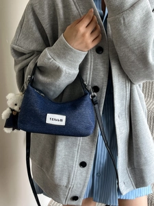 Deep blue denim baguette bag with cute bear charm and black shoulder strap for women