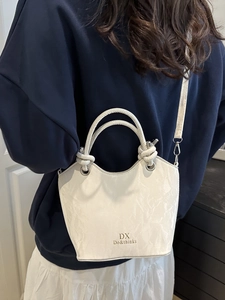 Modern white marble texture handbag with gold logo and elegant knotted top handle