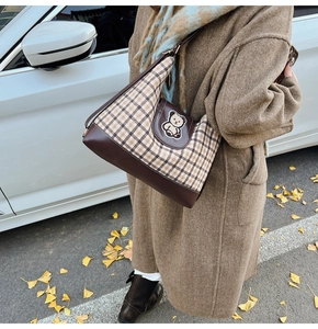 Detailed view of the vintage plaid tote bag with cute bear patch and brown leather straps