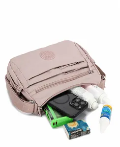 Internal view of a pink nylon crossbody bag showing spacious capacity for phone and makeup