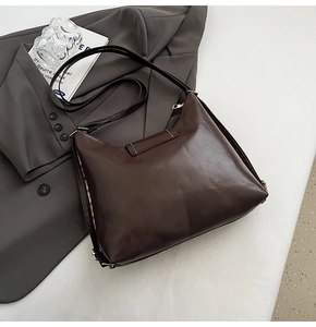 Detail view of smooth coffee brown PU leather tote bag with stylish checkered lining