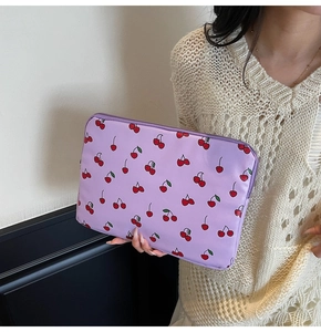 Detail einer lila Laptoptasche mit Kirschmuster und sicherem Reißverschluss