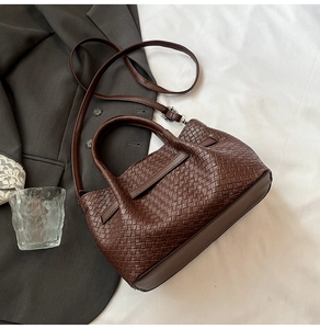 Close-up of dark brown woven checkerboard texture on fashion handbag with round handles
