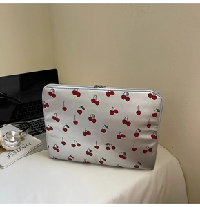 Laptop-Schutzhülle aus Satin mit Kirschmuster und Metallreißverschluss in Lifestyle-Szene