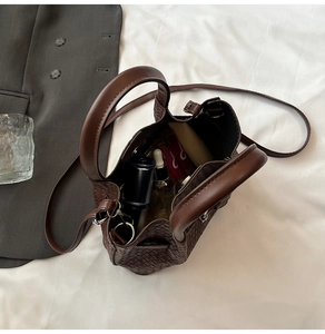 Detail of woven brown bucket bag showing spacious interior and texture in a lifestyle setting