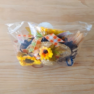 Dettaglio kit decorativo autunnale con girasoli, mini cappelli di paglia e nastri