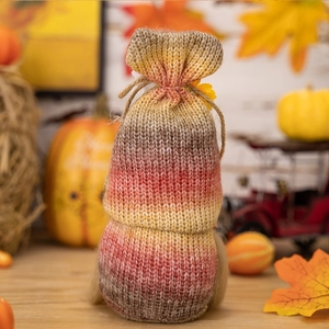 Close-up of knit Thanksgiving gnome hat with harvest pumpkin and gradient yarn texture