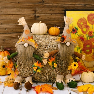 Fall harvest gnome figurines with burlap hats and sunflowers on rustic hay decor