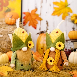 Gros plan de gnomes d'automne avec chapeaux en maïs et détails de tournesols sur foin
