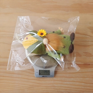 Détail d'un gnome de Thanksgiving pesant 147,5g sur une balance pour les spécifications