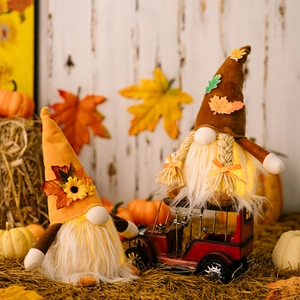 Close-up of lighted Thanksgiving gnomes with autumn leaves and glowing LED lights