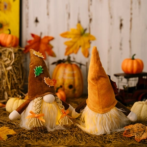 Detail of LED lighted harvest gnomes with autumn maple leaf hats on straw display
