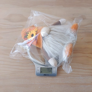 Detail shot of a Thanksgiving gnome with sunflower hat being weighed at 75.8g