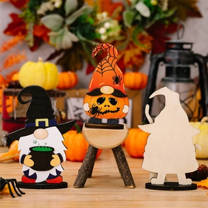 Close-up of wooden Halloween gnome set with pumpkin and witch hat on warm autumn background