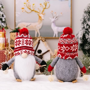 Close-up of plush Christmas gnome and penguin figurines with knitted hats and wooden skis