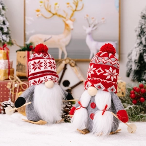Detail of Christmas gnomes on wooden skis with knitted snowflake hats and plush beards