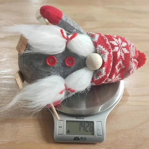 Detailed weight measurement of a Christmas gnome figurine on a digital kitchen scale