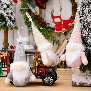 Close-up of three knitted Christmas gnomes with glitter stars in a festive scene