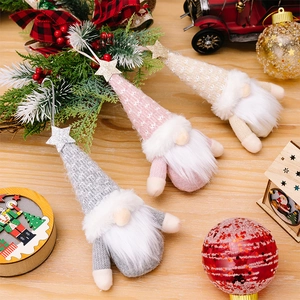 Detailed view of three knitted Christmas gnomes with glitter star hats and fuzzy beards