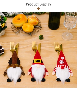 Detalle de porta cubiertos de gnomos de Navidad en mesa de madera decorada