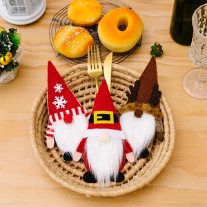 Tres gnomos navideños en una cesta sobre una mesa de comedor rústica decorada