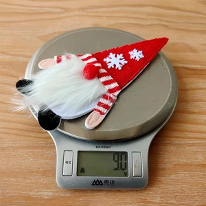Detalle de un portacubiertos de gnomo navideño que pesa 9,0g en una báscula de cocina digital