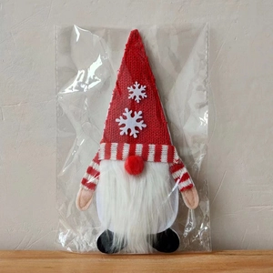 Detalle de porta cubiertos de gnomo navideño con gorro de punto rojo y barba blanca
