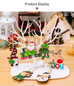 Detail of assorted wooden Christmas ornaments featuring Santa and reindeer on white stand