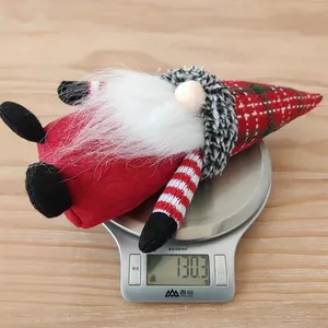 Gnomo di Natale di peluche con cappello a quadri che pesa 130,3g su una bilancia