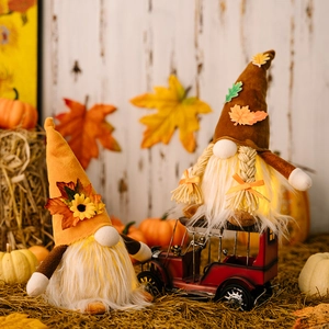 Lighted Thanksgiving gnomes with maple leaf hats and sunflowers on harvest scene