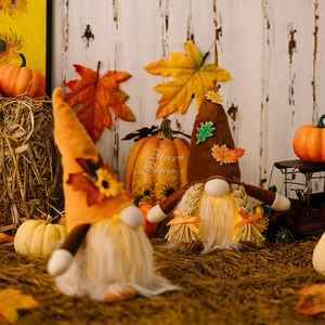 Lighted Thanksgiving gnomes with sunflower and harvest decorations on hay backdrop