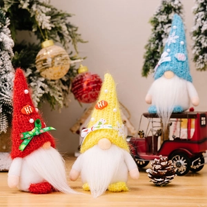 Close-up of three knitted Christmas gnomes with colorful hats and soft white faux fur beards
