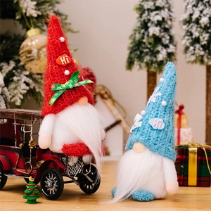 Detail of knitted Christmas gnomes with Hi hats and snowflakes next to a vintage red truck