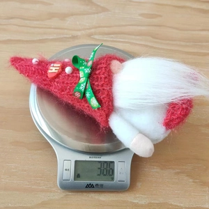 Detail shot showing the 38.6g weight of a knitted Christmas gnome on a digital scale