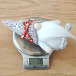 Close-up of a handmade Christmas gnome plush toy weighing 39.5g on a digital scale