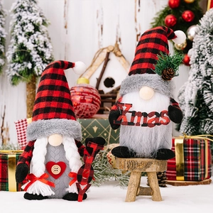 Dettaglio di gnomi natalizi in peluche con cappelli a quadri e cartelli con JOY e Xmas