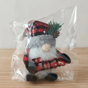 Dettaglio di uno gnomo di Natale con cappello a scacchi rossi e neri e segno Xmas