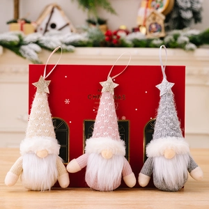 Three-piece Christmas gnome ornaments with knitted hats and sparkling stars on wooden surface