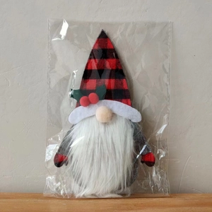 Detail of Christmas gnome cutlery holder in red buffalo plaid with holly decoration