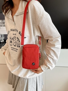 Elegant red nylon crossbody bag with casual pleated texture and adjustable webbing strap