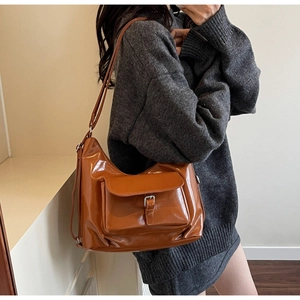 Détail du sac cabas brillant caramel avec boucle argentée et bandoulière réglable