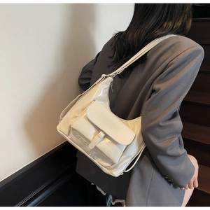 Détail d'un sac hobo en similicuir brillant crème avec une poche extérieure et élégante
