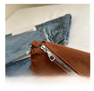Detail of a smooth silver metal zipper on a brown vintage matte suede shoulder bag texture