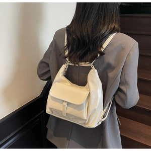Vue arrière du mannequin portant un sac à dos en cuir verni crème avec poche à rabat