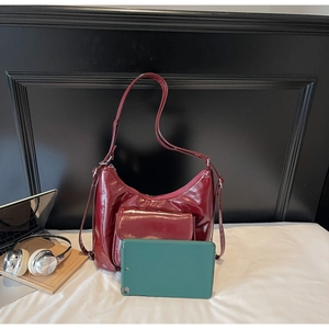 Détail du sac à main en cuir verni bordeaux avec poche à rabat magnétique et zip